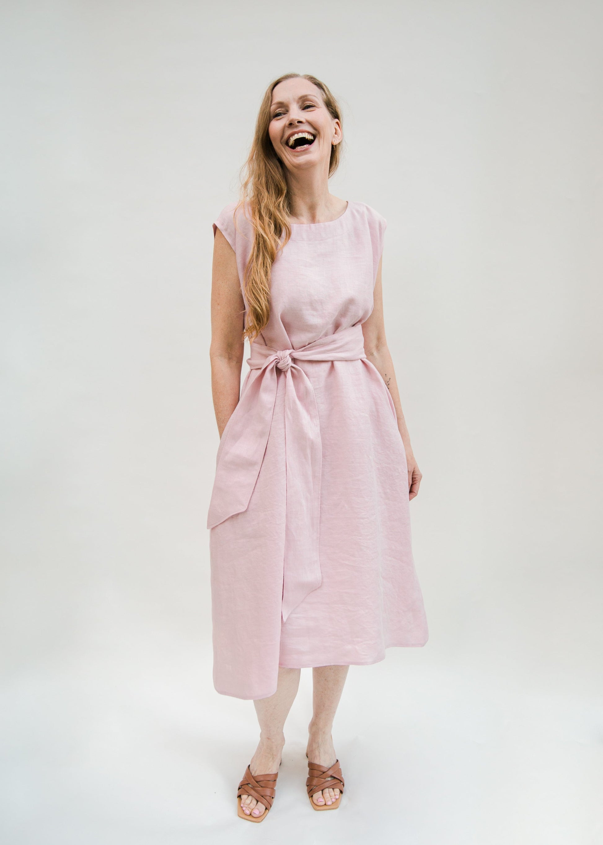 Woman wearing a pink dress with a white background